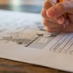 Hand filling in a printed ESL worksheet with a pencil